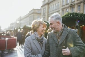 An older couple enjoying a high quality of life while walking in a city.