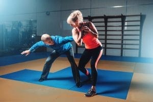 A man and a woman doing exercises in a gym.