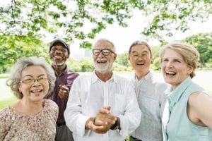 A group of senior people smiling in a park.