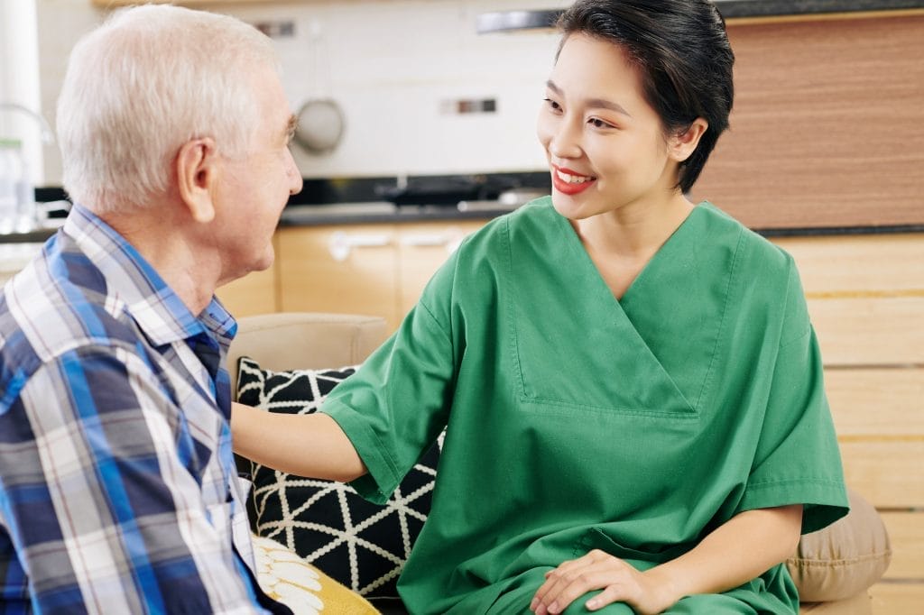 Female caregiver talking to senior patient