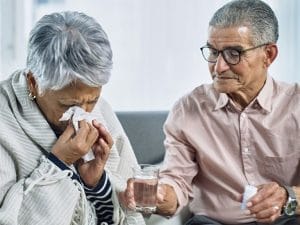 An elderly couple experiencing fluid on the lungs while holding a glass of water.