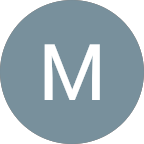 A gray circle with a white capital letter "M" centered inside, set against a light gray background—an elegant symbol representing Home Care Columbus.