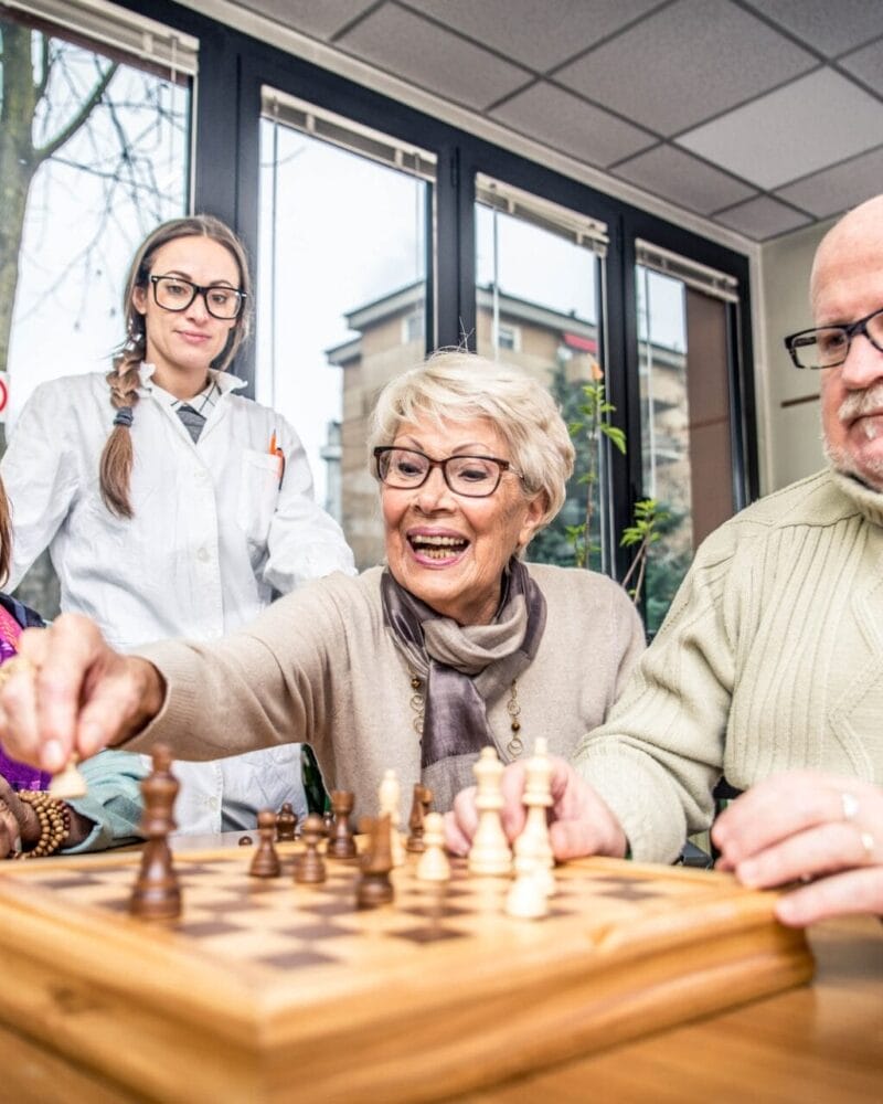A group of elderly people playing chess.